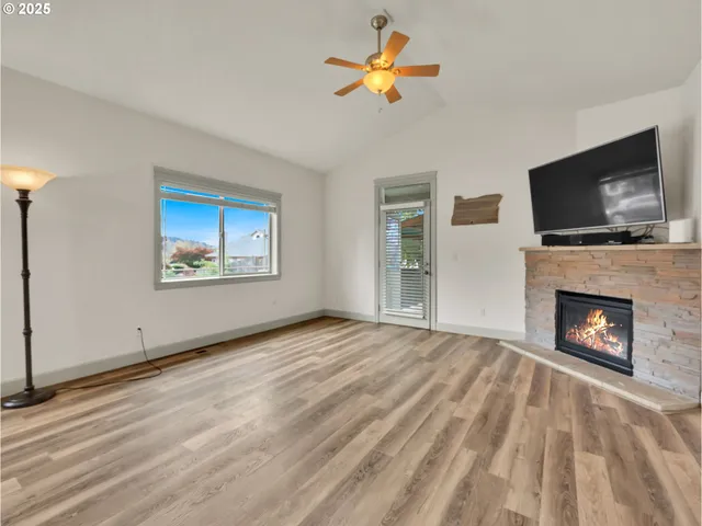 a view of empty room with a fireplace and flat screen tv