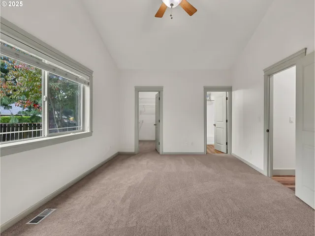 an empty room with a ceiling fan and window