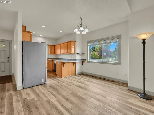 a view of kitchen with granite countertop cabinets and refrigerator
