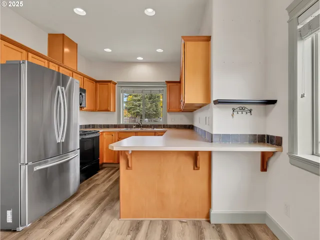 a kitchen with stainless steel appliances granite countertop a refrigerator a sink and a stove