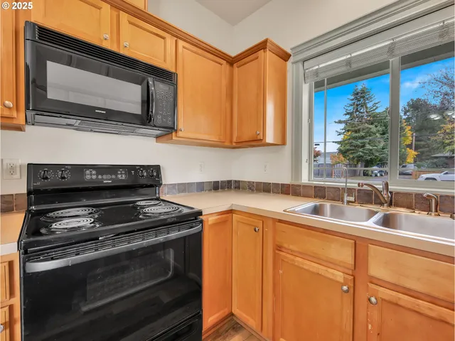 a kitchen with stainless steel appliances granite countertop a sink and a microwave