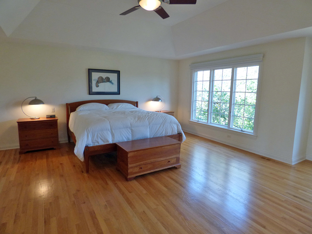 S130 Forbes Drive Geneva, IL 60134 - Photo 21 of 45 a spacious bedroom with a bed and a chandelier