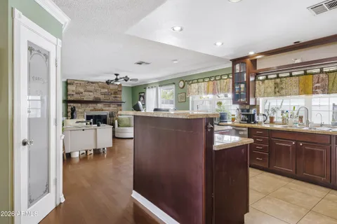 a kitchen with stainless steel appliances kitchen island granite countertop a refrigerator and cabinets
