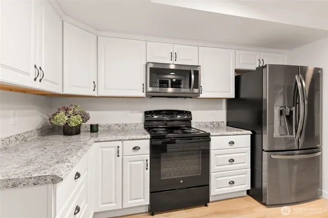 a kitchen with stainless steel appliances a refrigerator sink and microwave