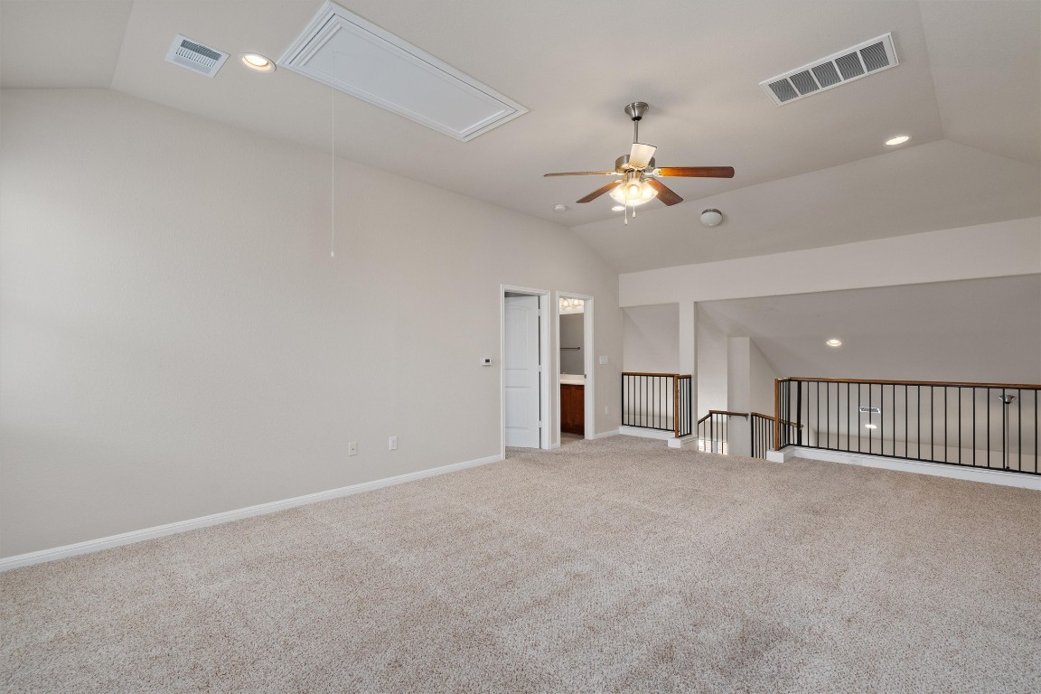 533 Jess Maynard Trail Leander, TX 78641 - Photo 18 of 24 Empty room featuring lofted ceiling, attic access, recessed lighting, light carpet, and a ceiling fan