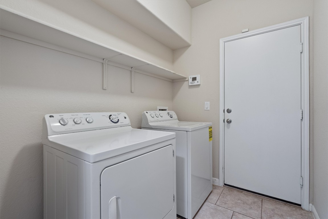 533 Jess Maynard Trail Leander, TX 78641 - Photo 19 of 24 Laundry area featuring light tile patterned flooring and washing machine and clothes dryer