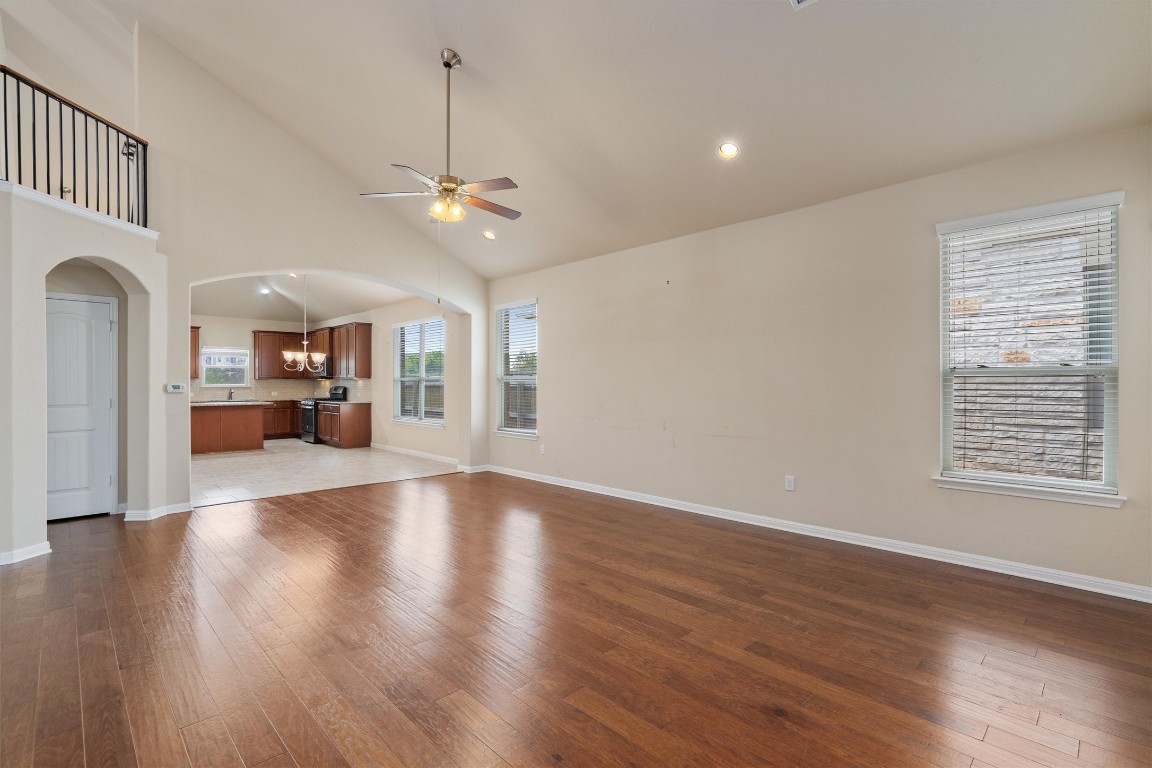 533 Jess Maynard Trail Leander, TX 78641 - Photo 5 of 24 Unfurnished living room with ceiling fan, dark wood-style floors, arched walkways, recessed lighting, and high vaulted ceiling