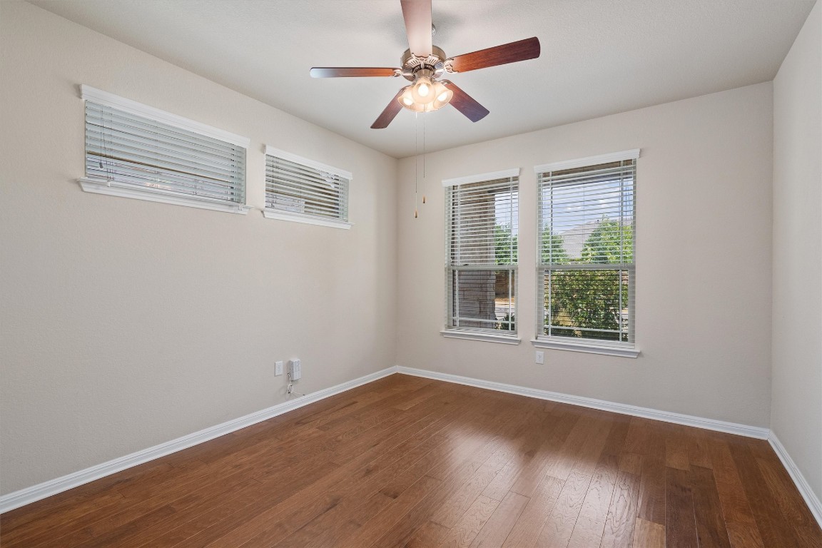 533 Jess Maynard Trail Leander, TX 78641 - Photo 7 of 24 Empty room featuring a ceiling fan and dark wood finished floors