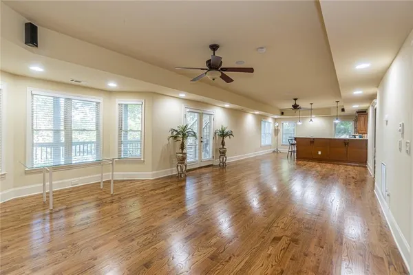 a living room with chairs a table and a potted plant