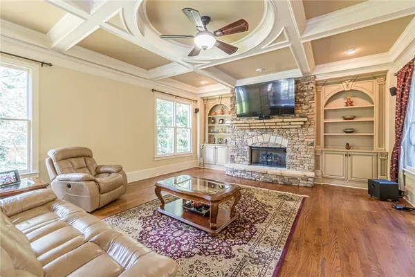 a living room with furniture a fireplace and a floor to ceiling window