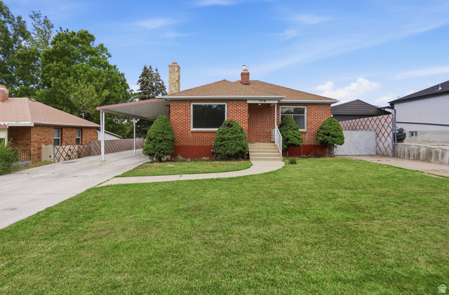 774 37th Street South Ogden, UT 84403 - Photo 34 of 47 Brick exterior residence featuring a front lawn, paved driveway, covered carport, and mature shrubs