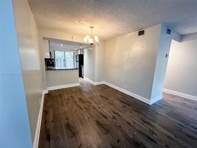 wooden floor in an empty room with a kitchen