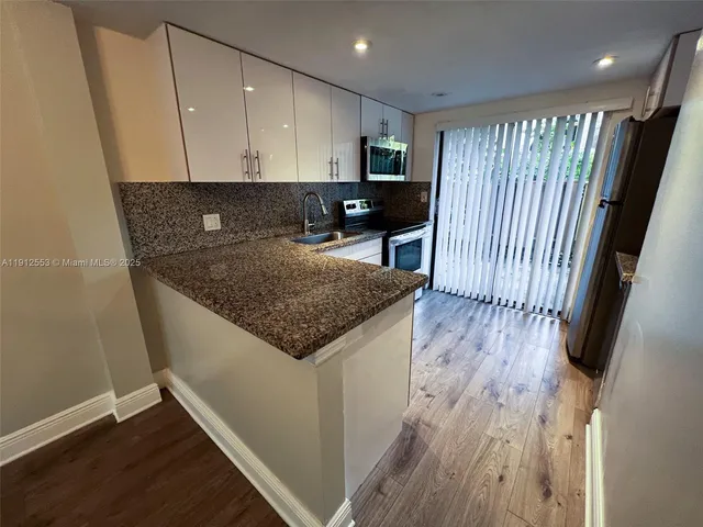 a kitchen with granite countertop a sink and a stove top oven