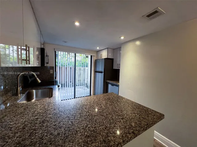 a view of a kitchen with a sink and a large window