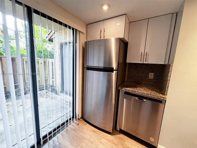 a view of kitchen with wooden floor and refrigerator