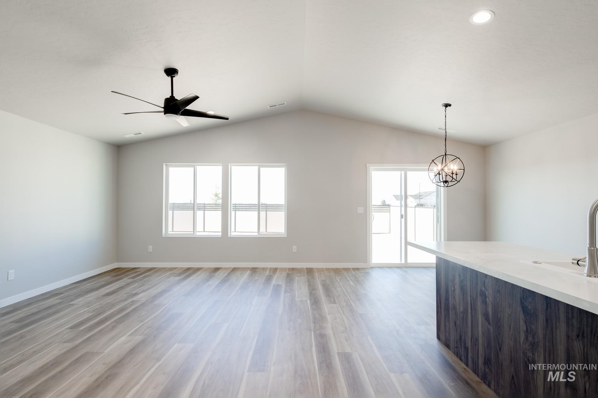 7256 South Menzingers Avenue Meridian, ID 83642 - Photo 10 of 23 Unfurnished dining area featuring recessed lighting, a chandelier, light wood finished floors, lofted ceiling, and a ceiling fan