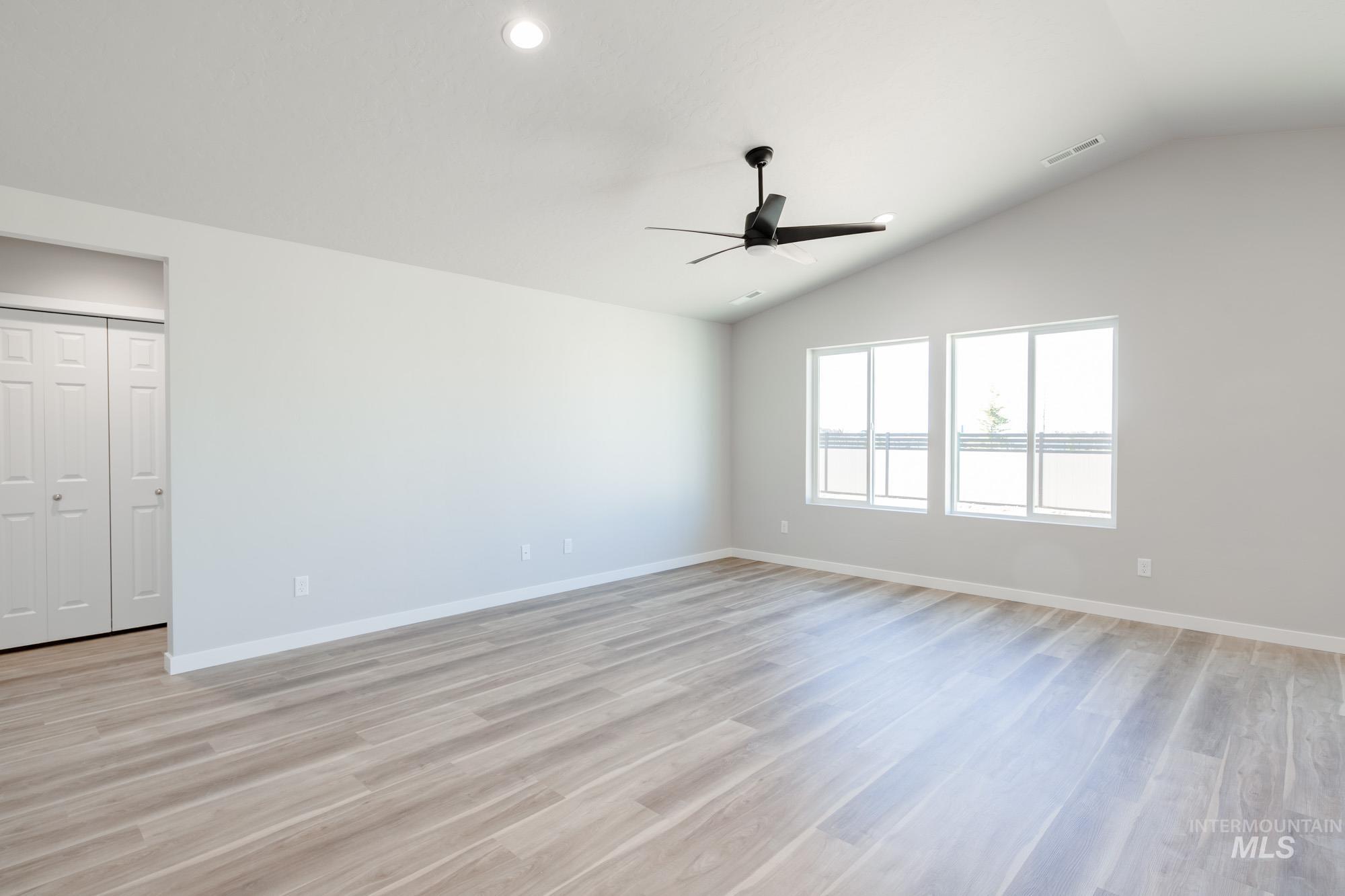 7256 South Menzingers Avenue Meridian, ID 83642 - Photo 11 of 23 Spare room featuring light wood-type flooring, lofted ceiling, recessed lighting, and a ceiling fan