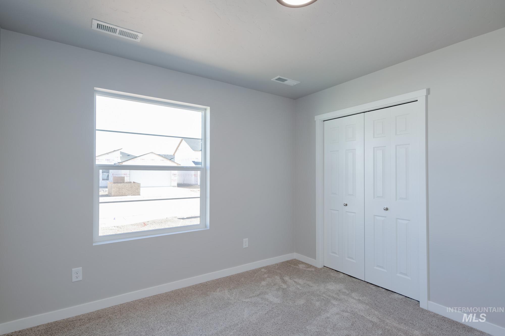 7256 South Menzingers Avenue Meridian, ID 83642 - Photo 13 of 23 Unfurnished bedroom with light colored carpet and a closet