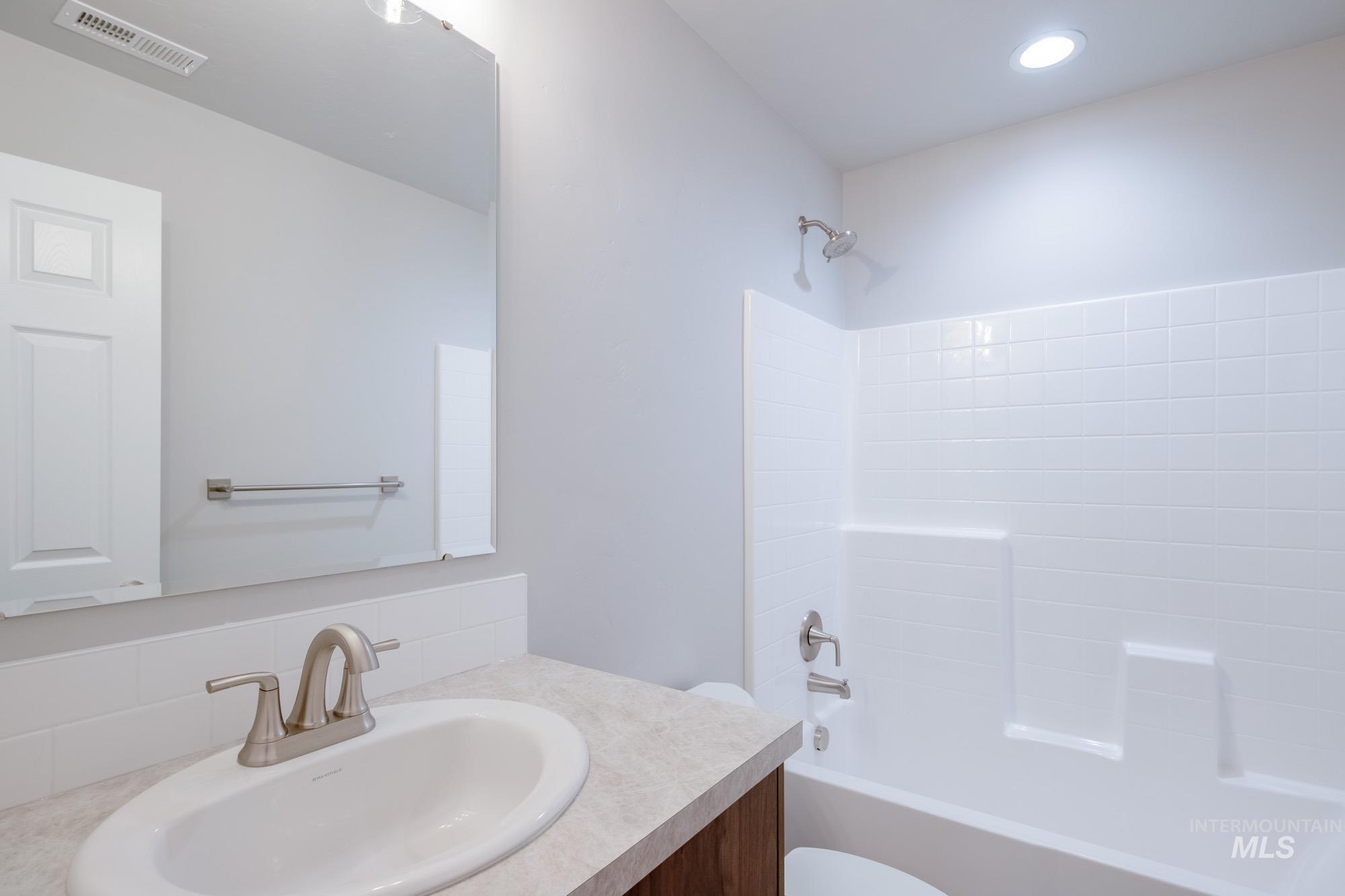 7256 South Menzingers Avenue Meridian, ID 83642 - Photo 15 of 23 Full bath with vanity, washtub / shower combination, and decorative backsplash