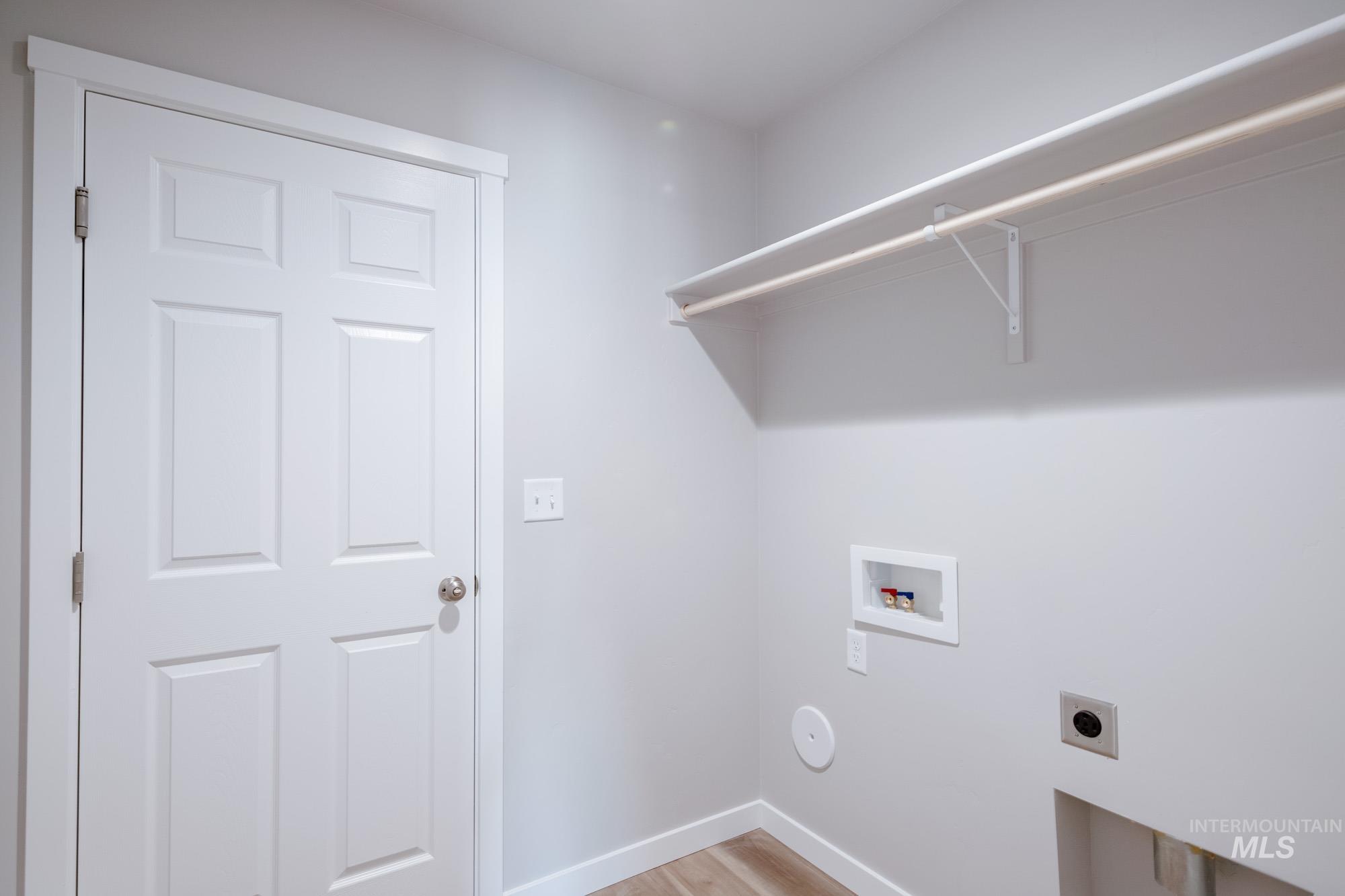 7256 South Menzingers Avenue Meridian, ID 83642 - Photo 16 of 23 Laundry room with electric dryer hookup, light wood-style flooring, and washer hookup