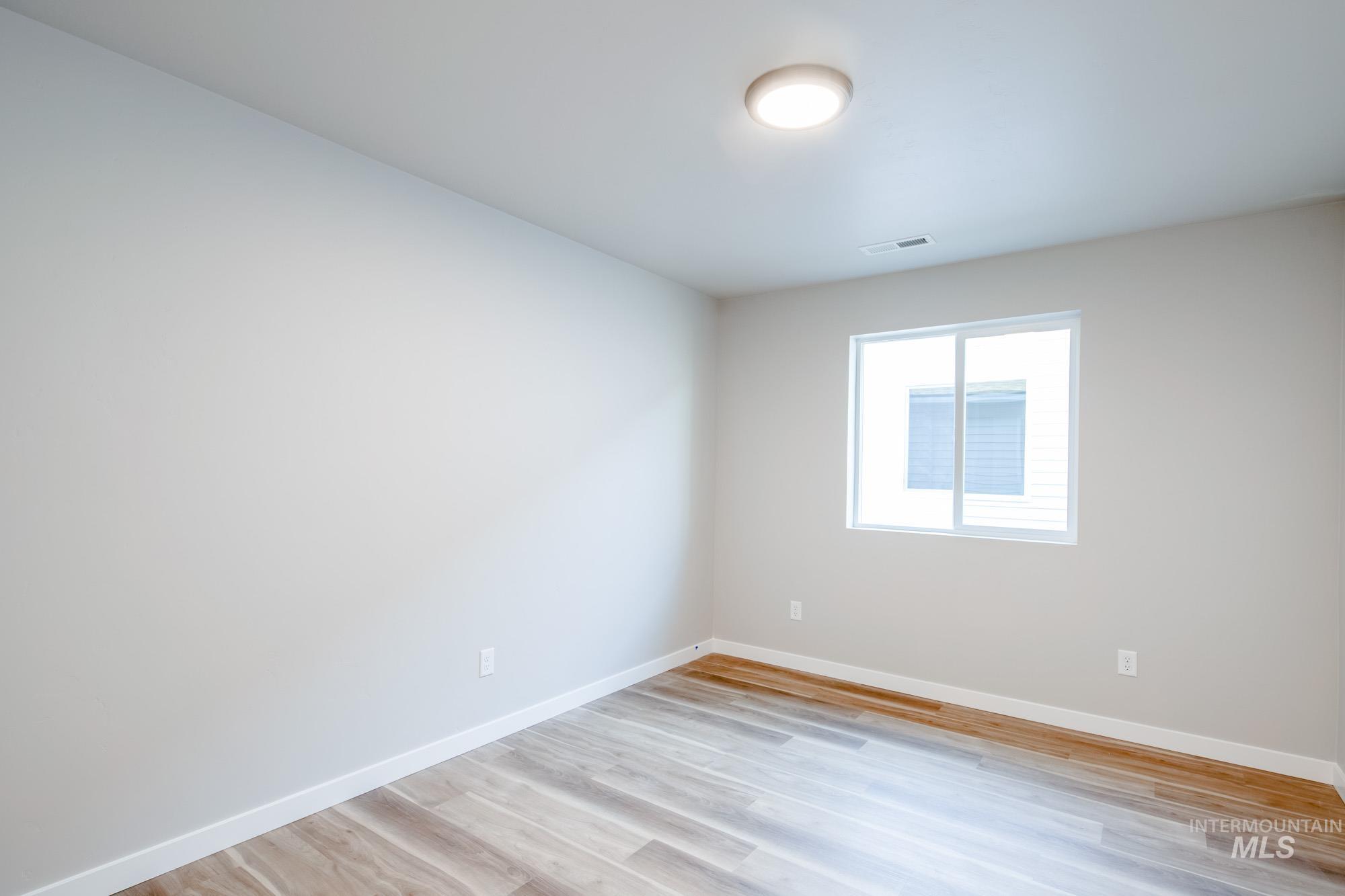 7256 South Menzingers Avenue Meridian, ID 83642 - Photo 17 of 23 Unfurnished room with baseboards and light wood finished floors
