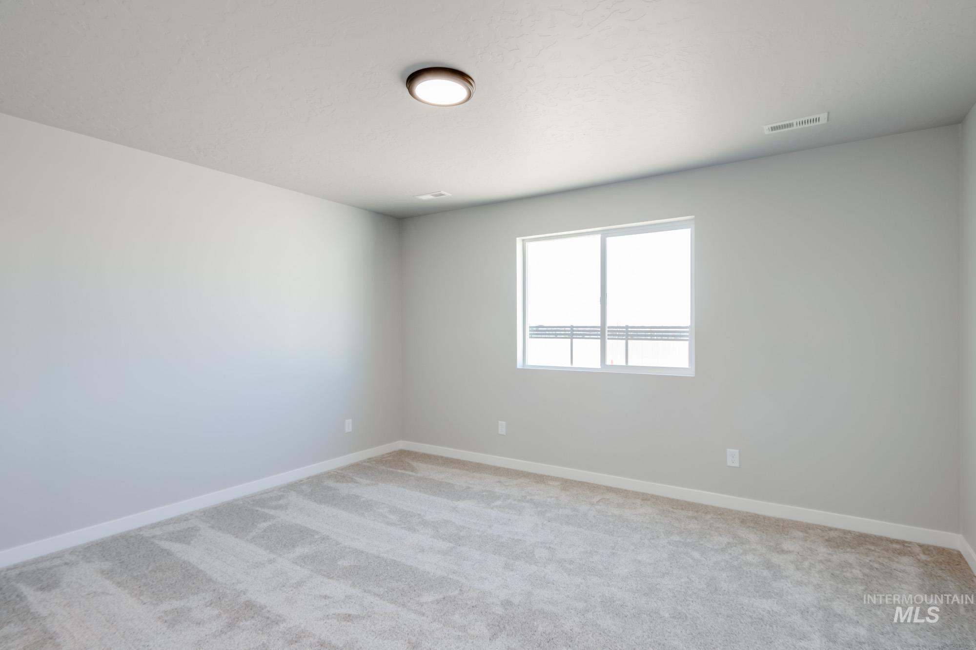7256 South Menzingers Avenue Meridian, ID 83642 - Photo 18 of 23 Empty room featuring baseboards and light carpet