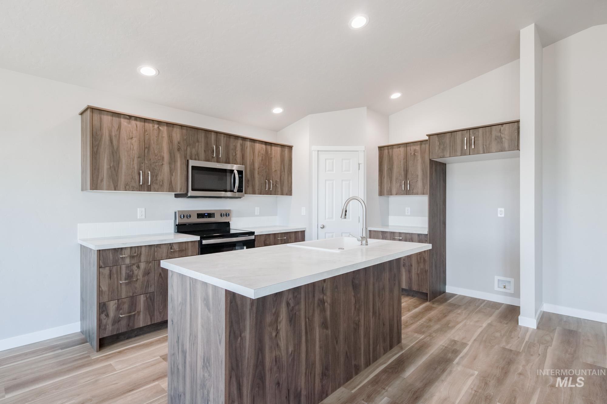 7256 South Menzingers Avenue Meridian, ID 83642 - Photo 9 of 23 Kitchen with stainless steel appliances, a kitchen island with sink, light wood-style floors, recessed lighting, and modern cabinets