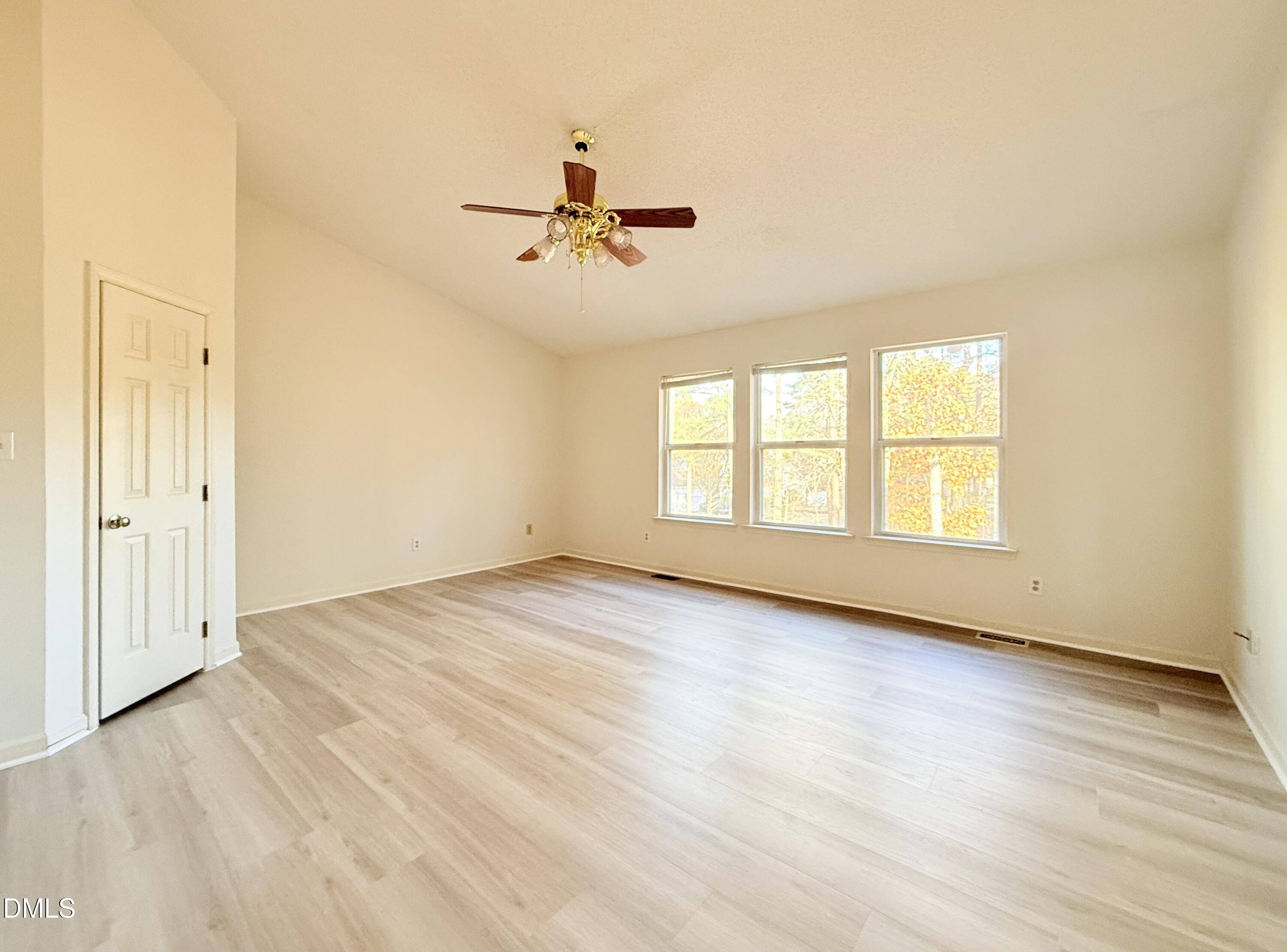 3610 Long Ridge Road Durham, NC 27703 - Photo 12 of 21 an empty room with wooden floor ceiling fan and windows