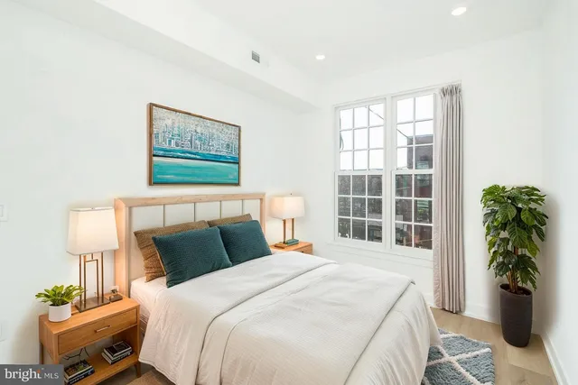 a bedroom with a bed potted plant and a window