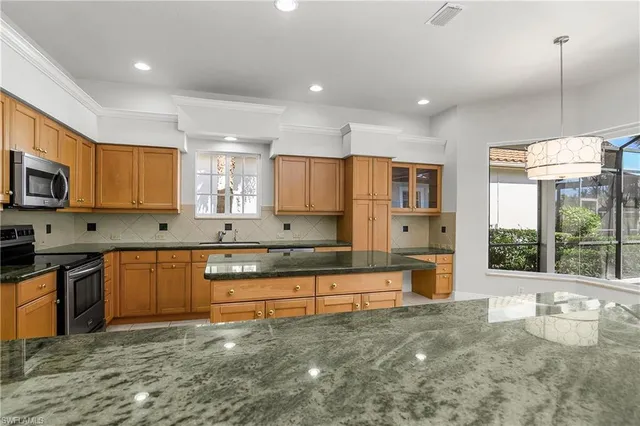 a kitchen with stainless steel appliances granite countertop a stove sink and cabinets