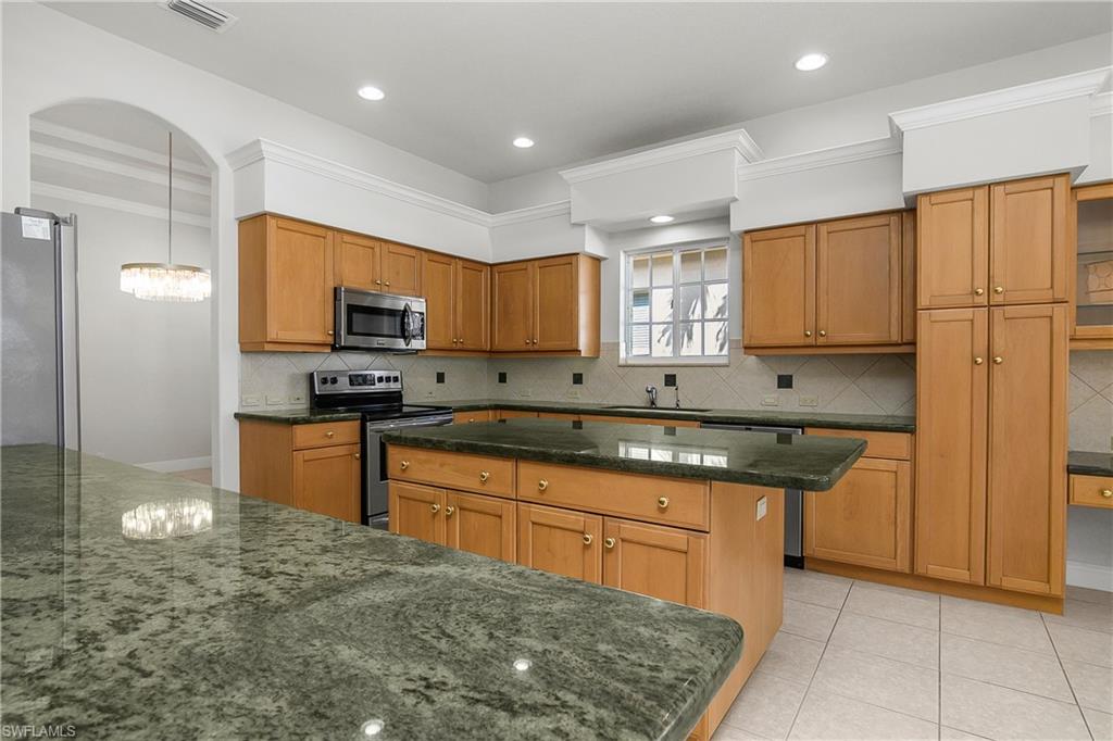 10160 Ginger Pointe Court Estero, FL 34135 - Photo 14 of 37 a kitchen with stainless steel appliances granite countertop a stove sink and cabinets