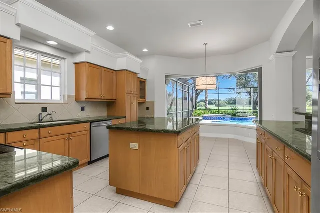 a kitchen with stainless steel appliances granite countertop a sink counter space cabinets and a large window