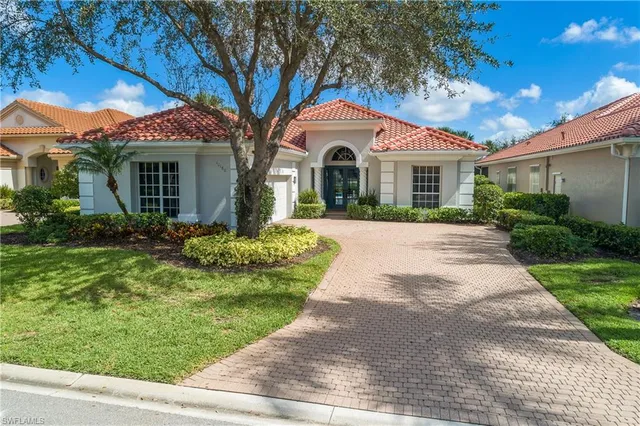 a front view of a house with a yard and potted plants