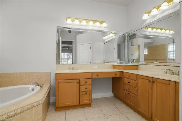 a spacious bathroom with a granite countertop sink mirror and bathtub