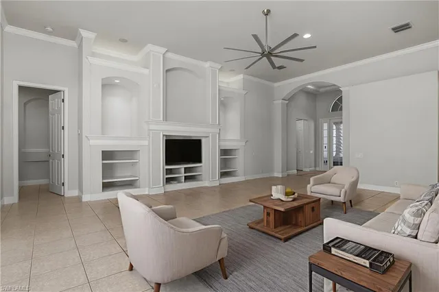 a living room with furniture ceiling fan and a fireplace