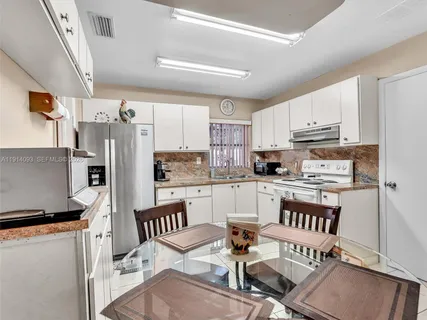 a kitchen with stainless steel appliances granite countertop a refrigerator and a stove top oven