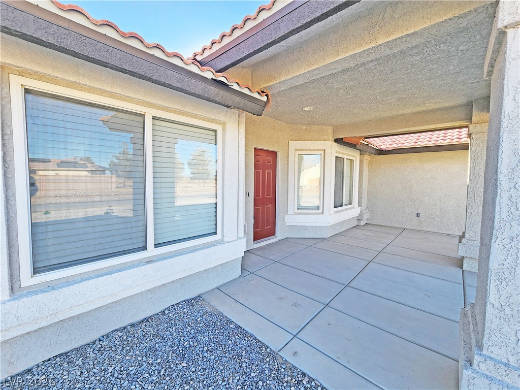 4591 Stoneham Street Pahrump, NV 89061 - Photo 4 of 42 A terracotta-tiled roof crowns this residence, featuring a vibrant red entry door.