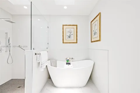 a white bath tub sitting next to a shower