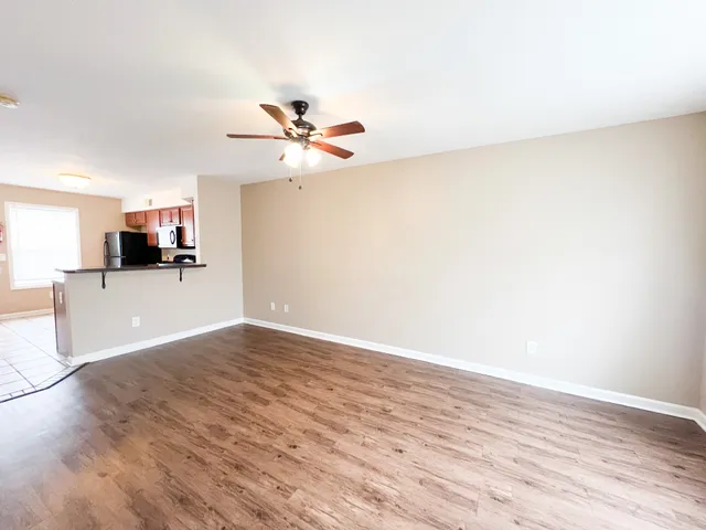 a view of a kitchen with wooden floor and a ceiling fan