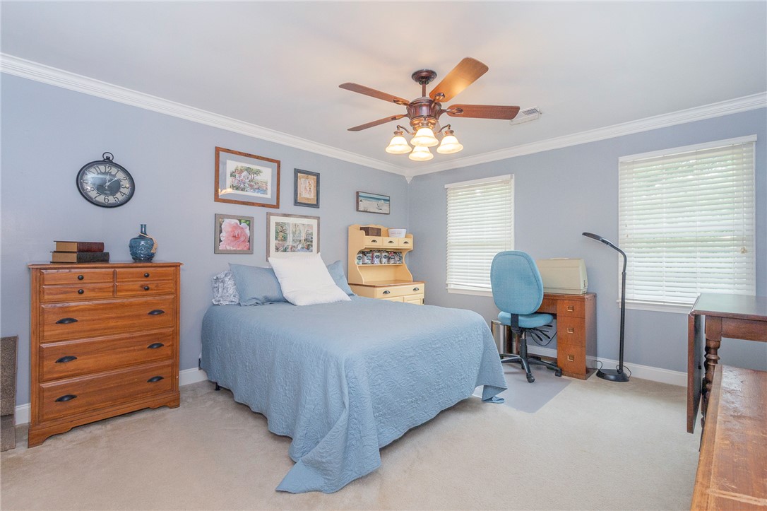 203 Oak Hollow Pendleton, SC 29670 - Photo 31 of 50 A comforting bedroom space, well-lit by natural light, features carpet flooring and a ceiling fan.