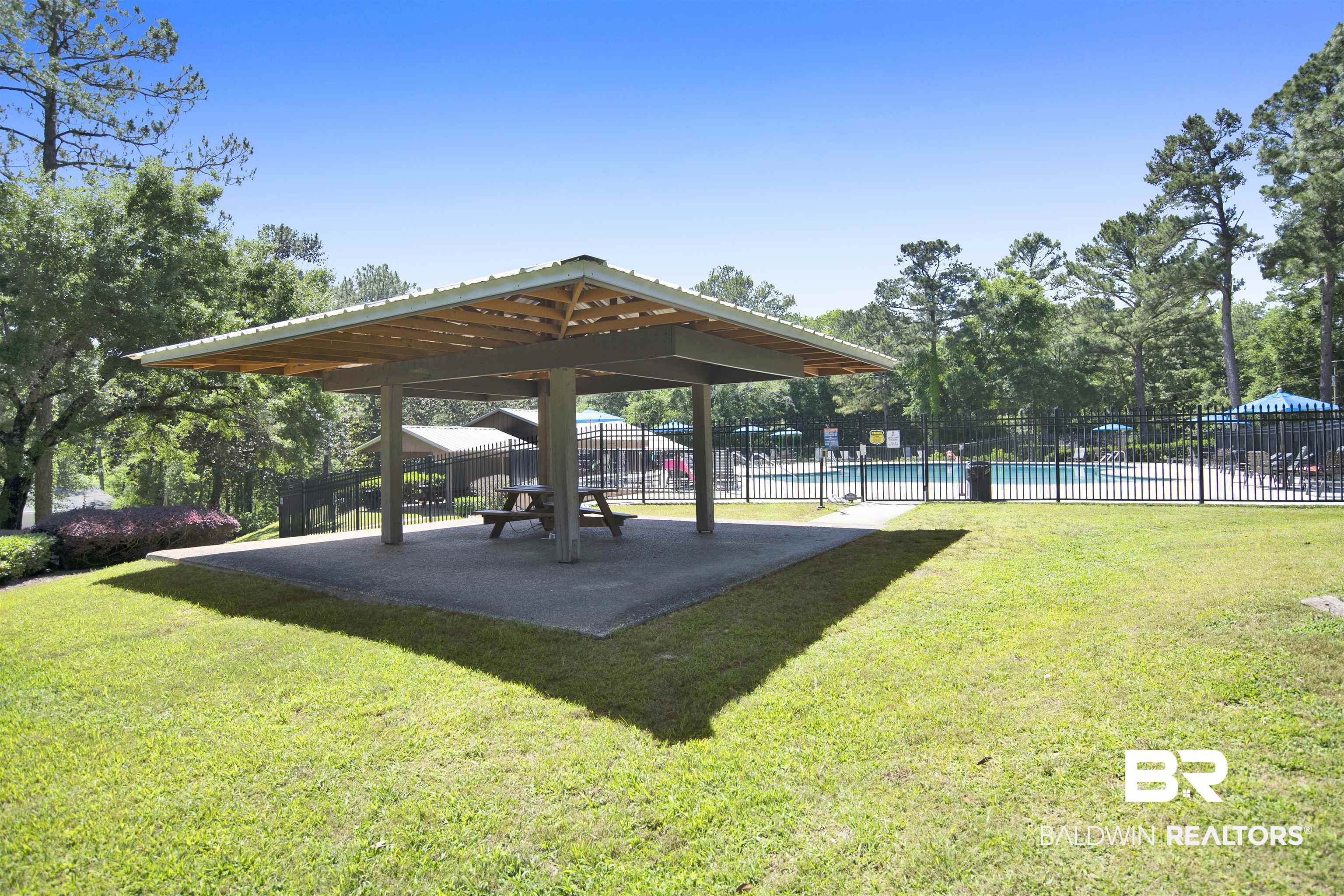 107 Virginia Circle Daphne, AL 36526 - Photo 46 of 47 Community amenity area featuring a covered picnic pavilion with concrete flooring, surrounded by a manicured lawn