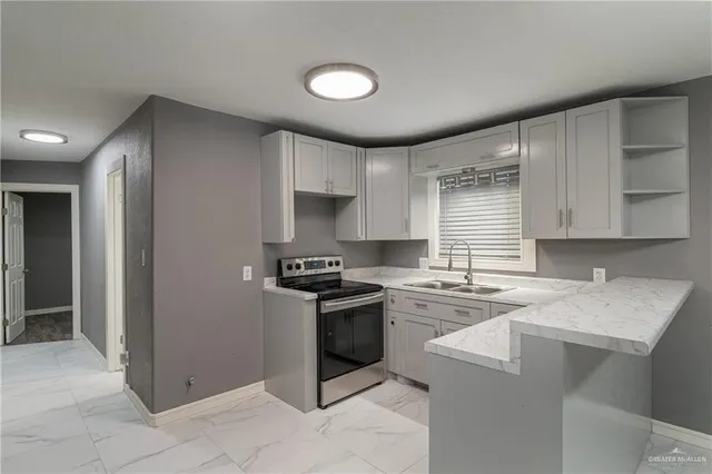a kitchen with a stove sink and cabinets