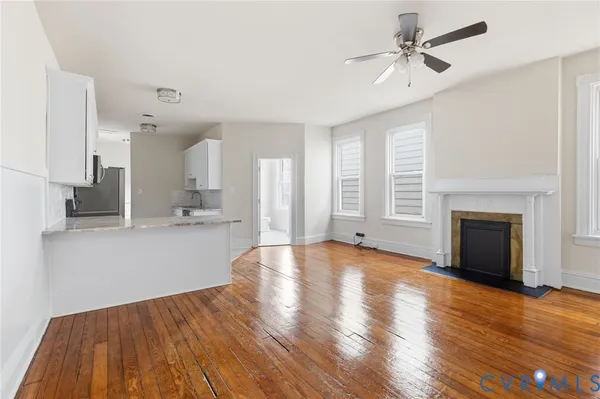 a view of empty room with wooden floor and fireplace