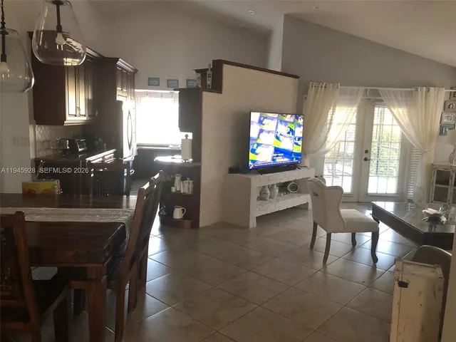 a living room with furniture a flat screen tv and a large window