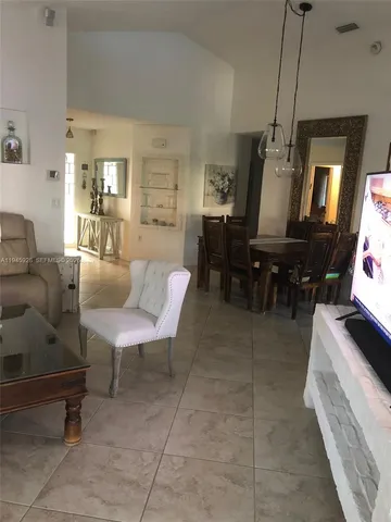 a living room with furniture a dining table and a piano