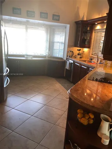 a kitchen with stainless steel appliances granite countertop a sink and a microwave