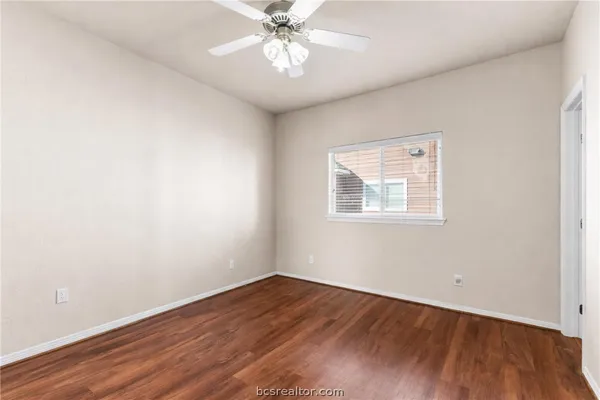 a view of a workspace with wooden floor and a window