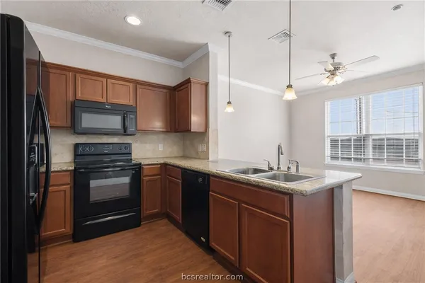 a kitchen with stainless steel appliances granite countertop a refrigerator and a sink