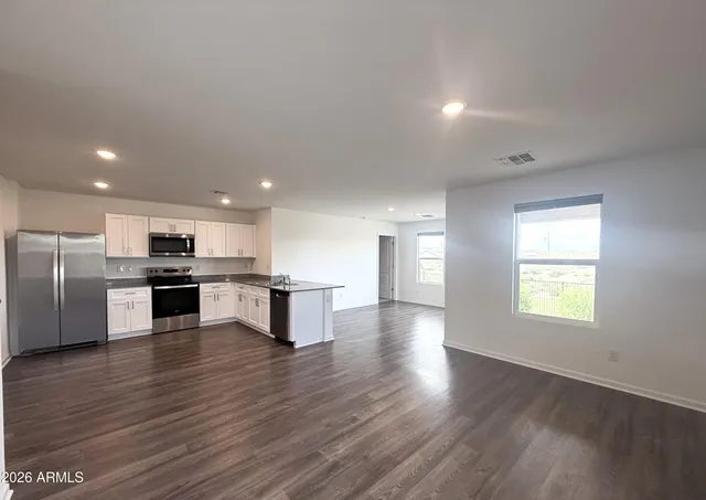 a view of kitchen with wooden floor and electronic appliances