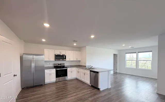 a kitchen with stainless steel appliances granite countertop a refrigerator and a stove top oven